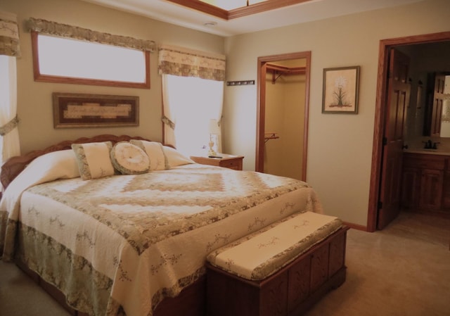 bedroom with ensuite bath, carpet flooring, sink, and a closet