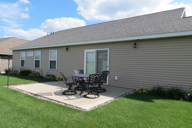 back of property with a lawn and a patio area