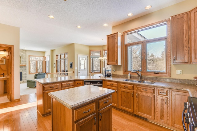 kitchen with sink, hanging light fixtures, a center island, stainless steel range, and a brick fireplace