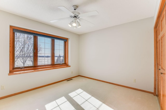 spare room featuring ceiling fan and light colored carpet