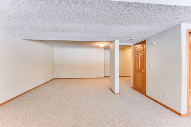 basement featuring light carpet and a textured ceiling