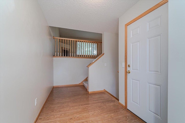 entrance foyer with a textured ceiling and light hardwood / wood-style flooring