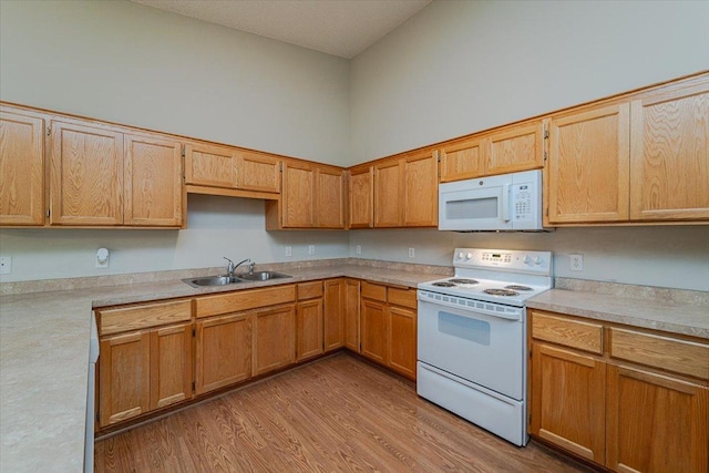 kitchen with sink, high vaulted ceiling, light hardwood / wood-style floors, and white appliances