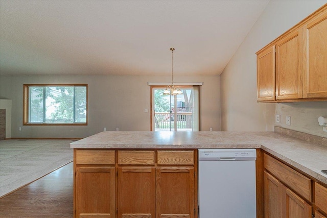 kitchen with pendant lighting, white dishwasher, hardwood / wood-style flooring, kitchen peninsula, and a chandelier