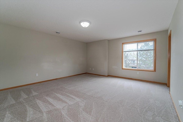 carpeted spare room with a textured ceiling