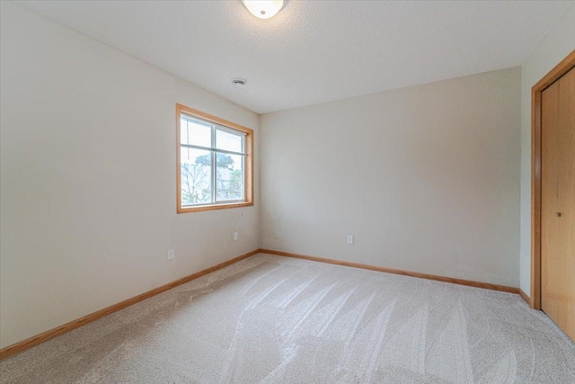 unfurnished bedroom featuring carpet floors, a textured ceiling, and a closet