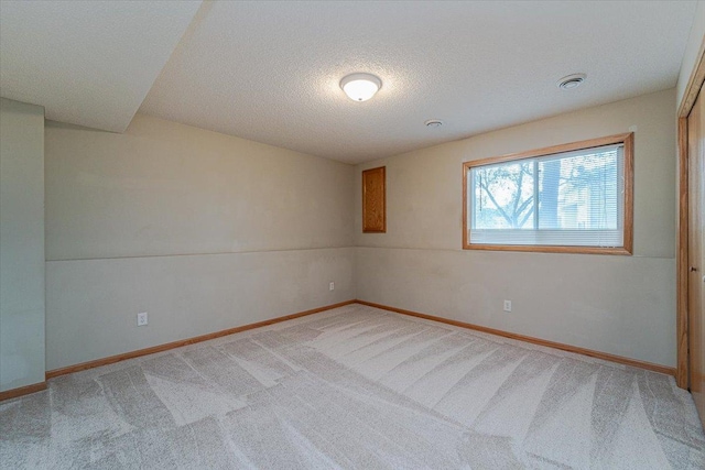 carpeted spare room featuring a textured ceiling