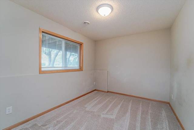 carpeted empty room featuring a textured ceiling