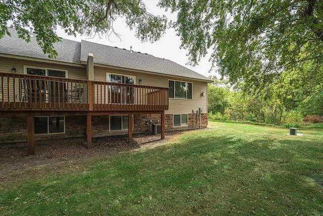 rear view of property with a lawn, central AC unit, and a deck