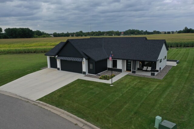 view of front of house featuring a garage, a rural view, and a front yard