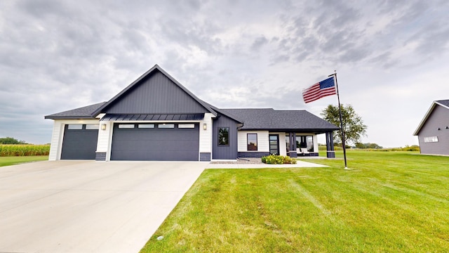 modern inspired farmhouse featuring a front yard, a porch, and a garage