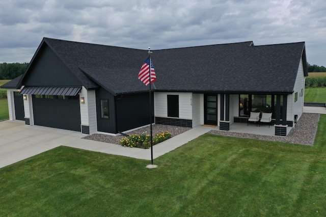 view of front of house featuring a patio area, a front yard, and a garage