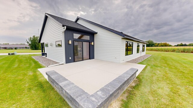 rear view of house featuring a patio and a yard