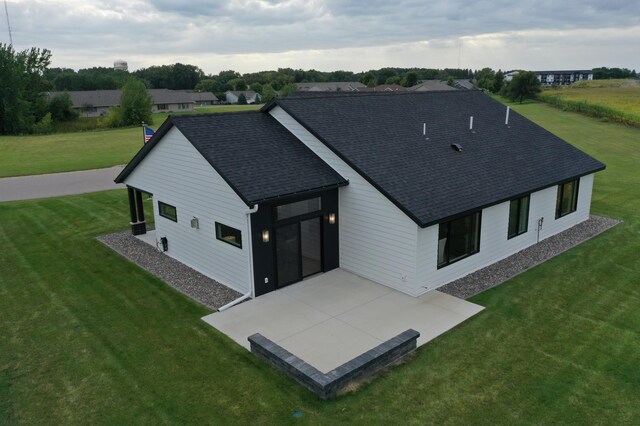 rear view of house featuring a lawn and a patio area