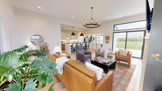 living room with a notable chandelier and light hardwood / wood-style floors