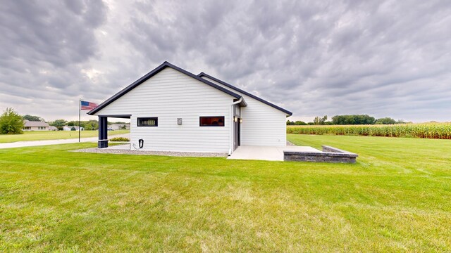 view of side of home with a lawn and a patio