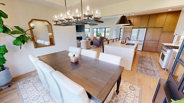 dining space featuring light wood-type flooring and sink