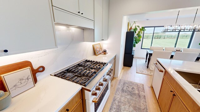 kitchen with pendant lighting, white appliances, light hardwood / wood-style flooring, a chandelier, and white cabinetry