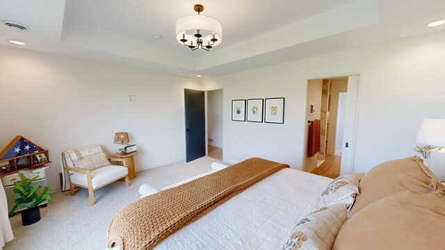 bedroom featuring a notable chandelier and a raised ceiling