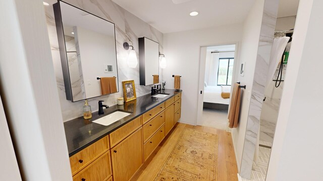 bathroom with walk in shower, vanity, and hardwood / wood-style flooring