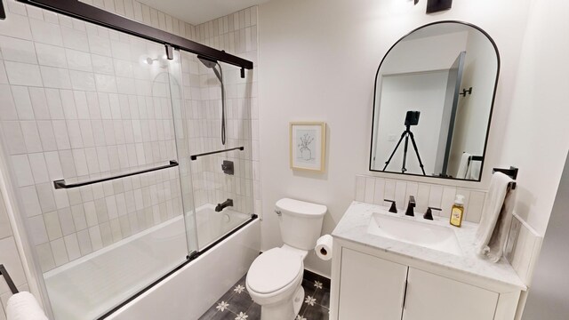 full bathroom with bath / shower combo with glass door, vanity, and toilet