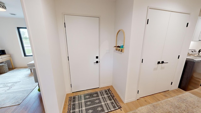 entrance foyer featuring light hardwood / wood-style floors and washer / dryer