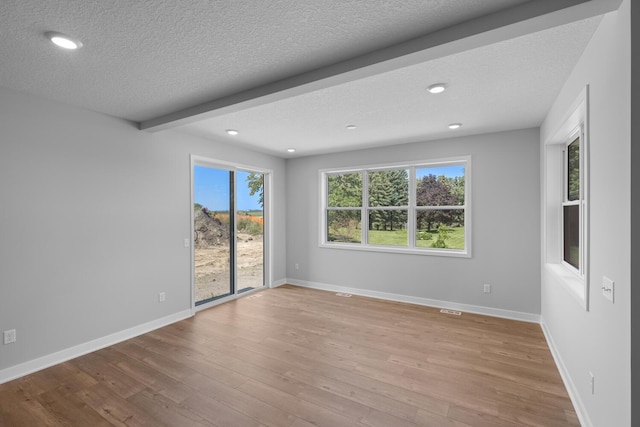 unfurnished room featuring a textured ceiling, baseboards, wood finished floors, and recessed lighting