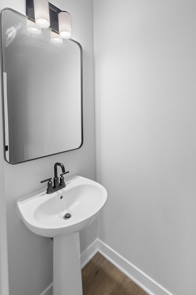 bathroom featuring a sink, wood finished floors, and baseboards