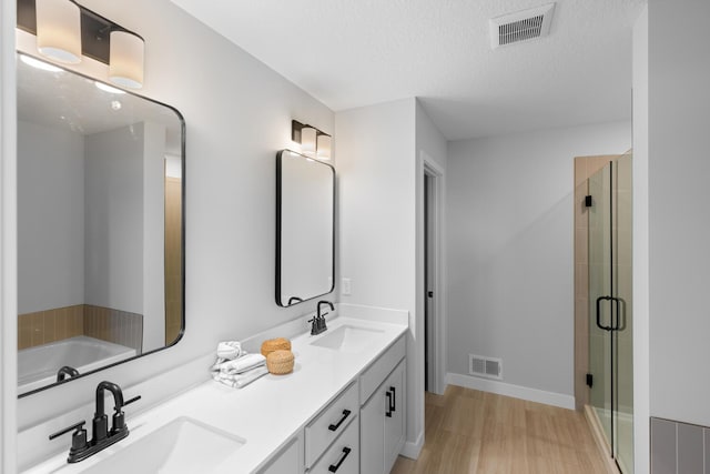 full bath with a shower stall, visible vents, and a sink