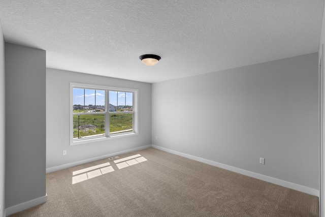 unfurnished room featuring carpet floors, baseboards, and a textured ceiling