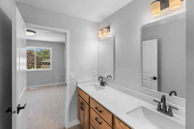 full bath featuring double vanity, baseboards, and a sink