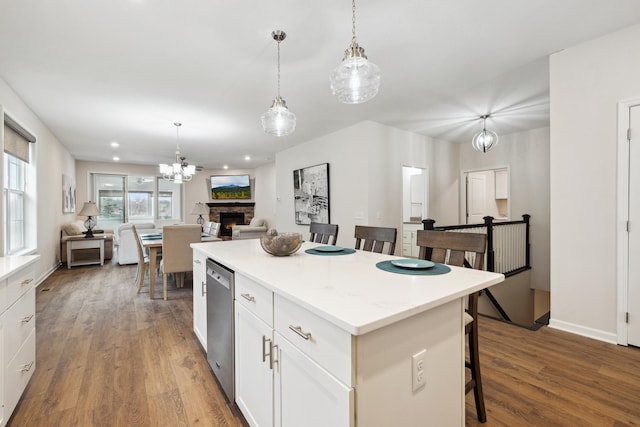 kitchen featuring a kitchen island, white cabinetry, hanging light fixtures, and a kitchen bar