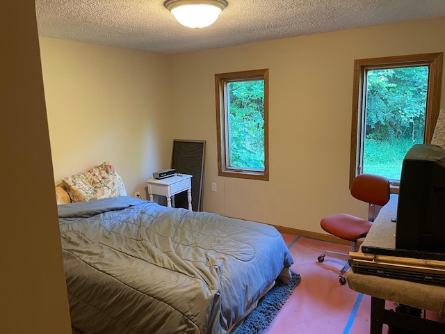 bedroom featuring multiple windows and a textured ceiling