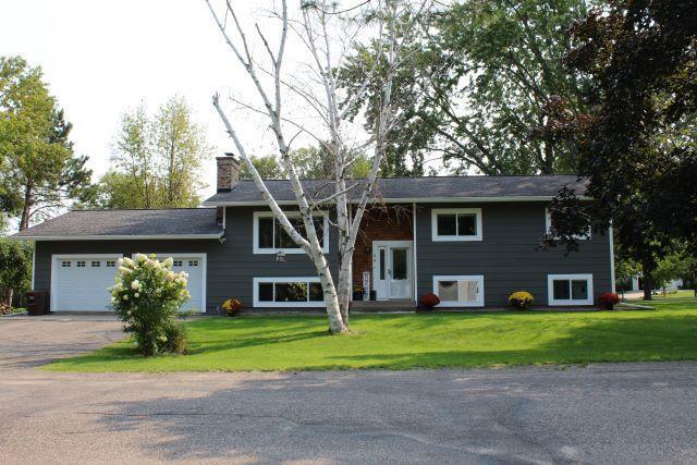 bi-level home featuring a garage and a front yard