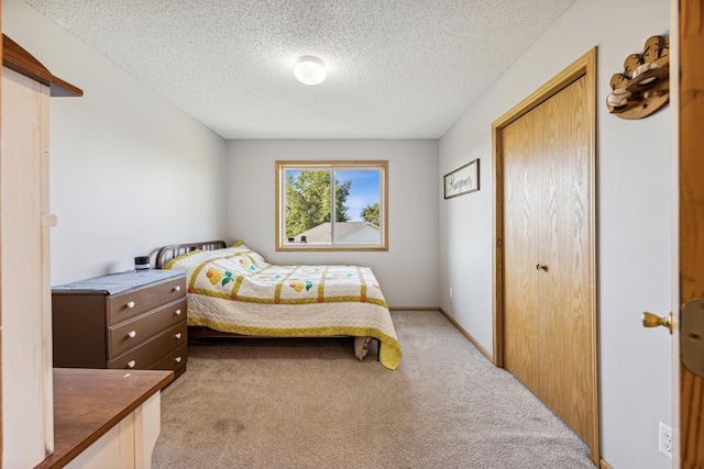 carpeted bedroom featuring a textured ceiling and a closet