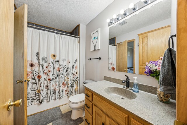 full bathroom featuring shower / bathtub combination with curtain, toilet, a textured ceiling, and vanity