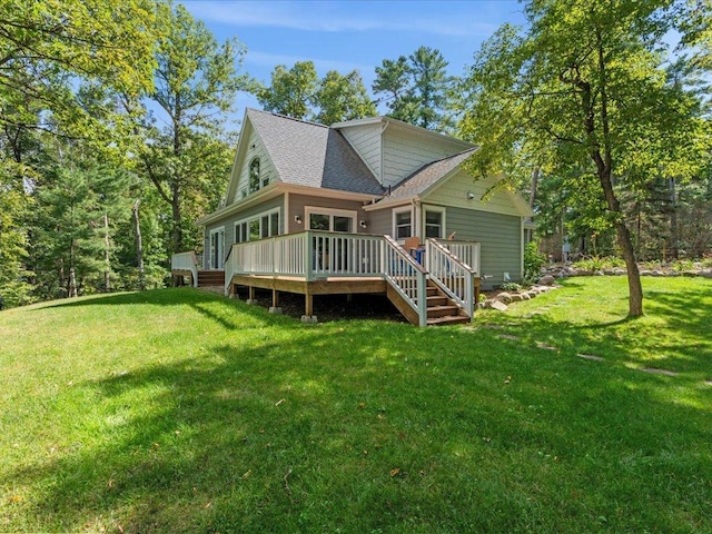 back of property featuring a yard, roof with shingles, and a deck