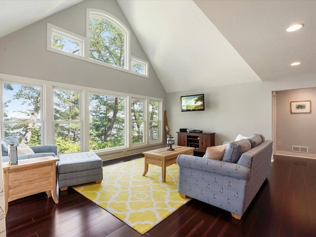 living area with dark wood finished floors, visible vents, recessed lighting, and high vaulted ceiling