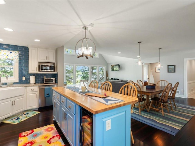 kitchen featuring beverage cooler, butcher block countertops, white cabinets, and stainless steel appliances