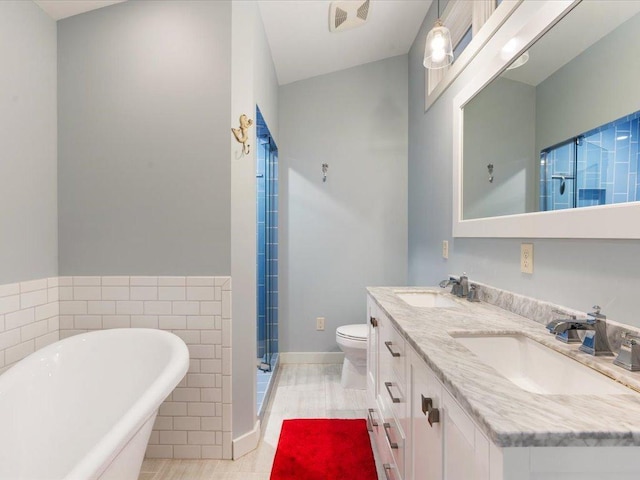 bathroom featuring a soaking tub, double vanity, visible vents, and a sink