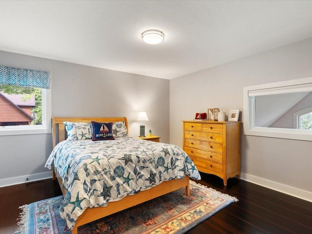 bedroom featuring baseboards and dark wood-style flooring