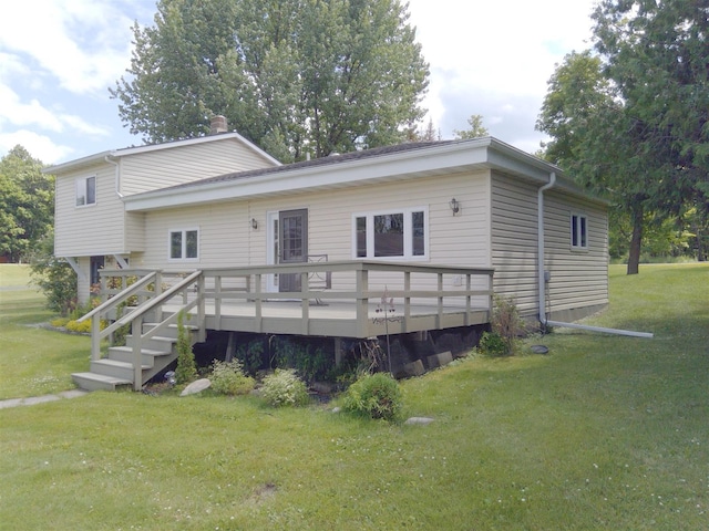 rear view of property featuring a yard and a wooden deck