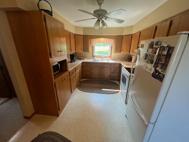 kitchen featuring ceiling fan, sink, and white appliances