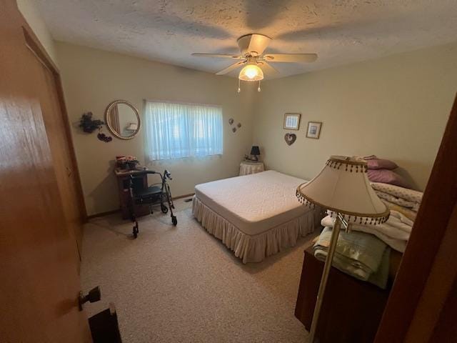 carpeted bedroom with a textured ceiling and ceiling fan