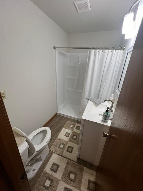 bathroom with a shower with shower curtain, toilet, hardwood / wood-style flooring, and vanity