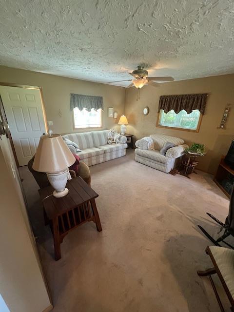 bedroom featuring a textured ceiling, ceiling fan, and carpet floors