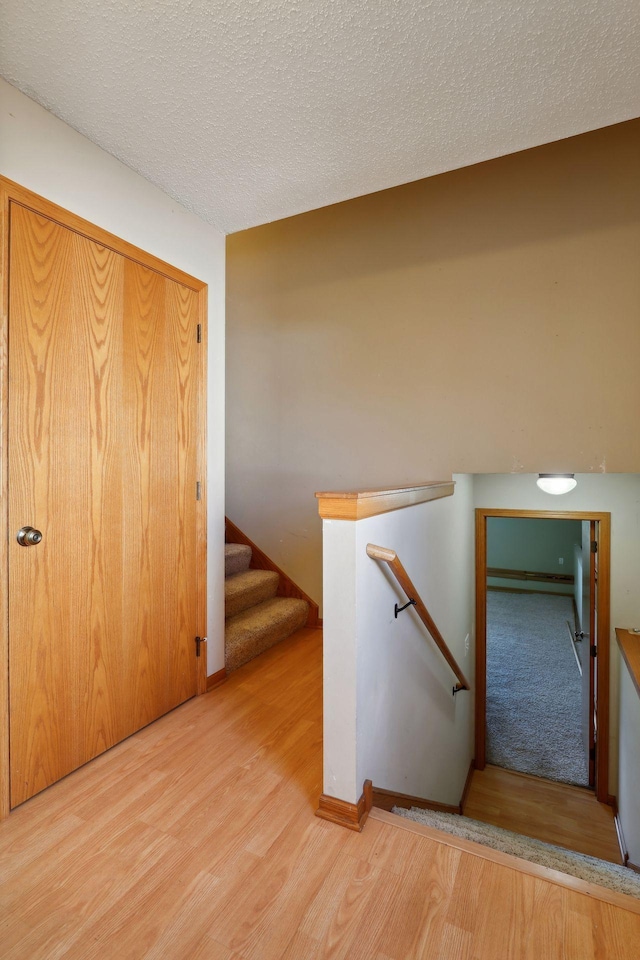 stairway featuring a textured ceiling and hardwood / wood-style floors