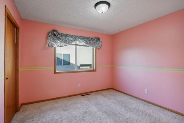 carpeted spare room featuring a textured ceiling