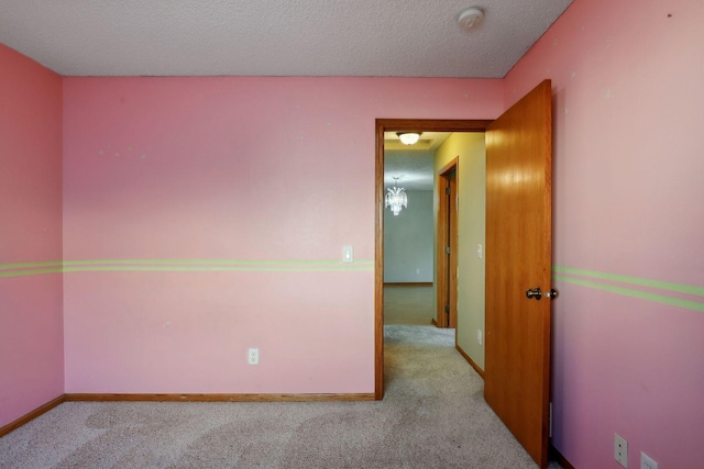 carpeted spare room featuring a textured ceiling