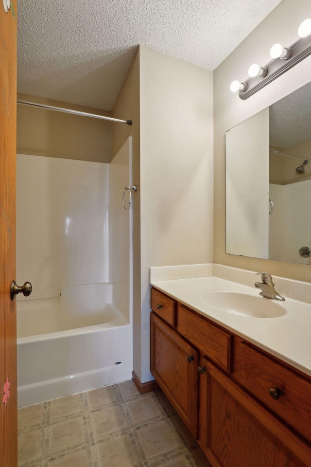 bathroom featuring tub / shower combination, a textured ceiling, and vanity